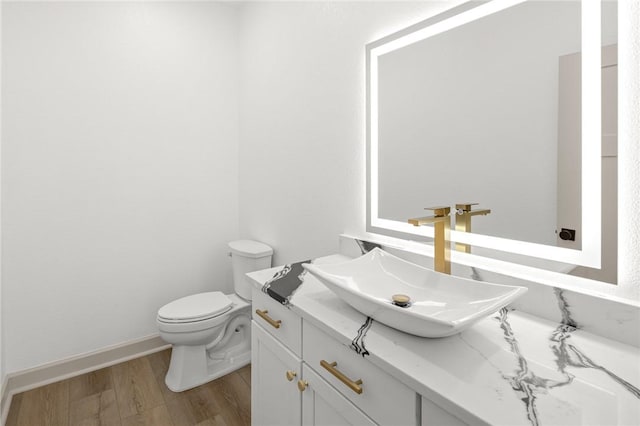 220 N C St, Rogers, AR 72756 - bathroom with wood finished floors, toilet, vanity, and baseboards