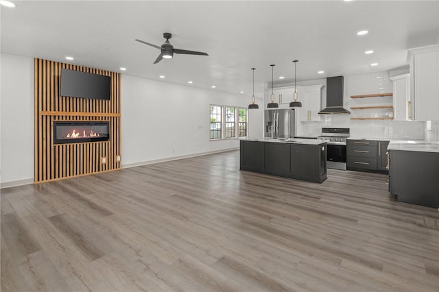 220 N C St, Rogers, AR 72756 - kitchen featuring appliances with stainless steel finishes, wall chimney range hood, open floor plan, open shelves, and light countertops