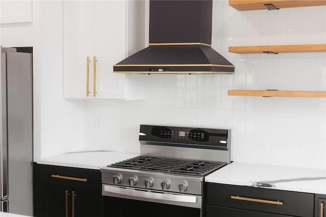 220 N C St, Rogers, AR 72756 - kitchen featuring wall chimney exhaust hood, stainless steel appliances, open shelves, light countertops, and dark cabinetry
