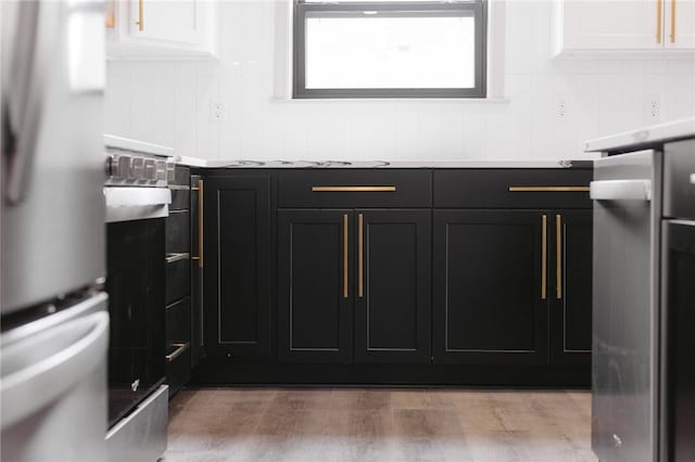 220 N C St, Rogers, AR 72756 - kitchen view of appliances with stainless steel finishes, dark cabinets, light countertops, and light wood finished floors