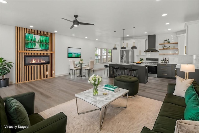 220 N C St, Rogers, AR 72756 - living room featuring a glass covered fireplace, ceiling fan, recessed lighting, and light wood-style floors