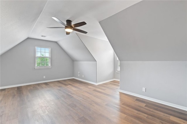 additional living space featuring wood finished floors, ceiling fan, vaulted ceiling, and baseboards