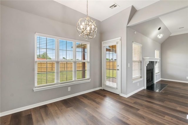 unfurnished dining area with vaulted ceiling, a chandelier, wood finished floors, baseboards, and a premium fireplace