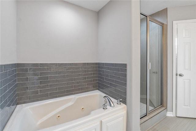 bathroom with a shower stall, a tub with jets, and tile patterned flooring