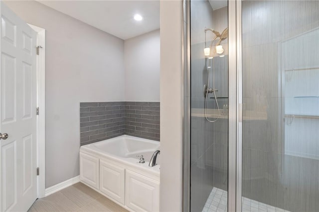 bathroom with a bath, a stall shower, and tile patterned flooring
