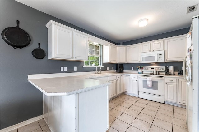 kitchen featuring visible vents, light tile patterned floors, a sink, white appliances, and a peninsula