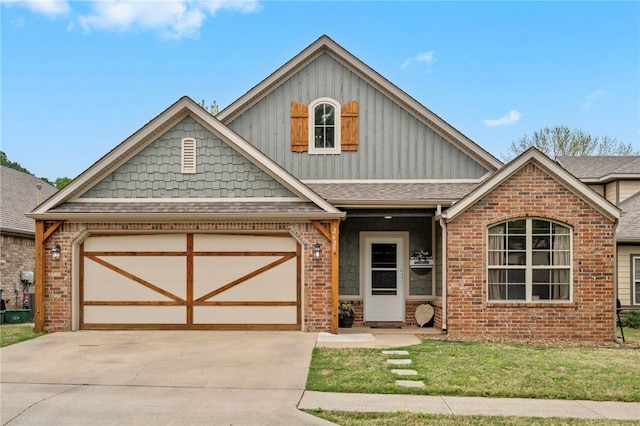 craftsman house featuring a front lawn, driveway, a shingled roof, an attached garage, and brick siding
