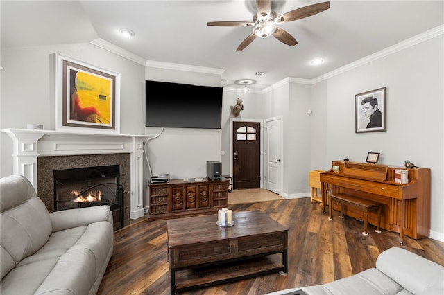 living room featuring a warm lit fireplace, wood finished floors, a ceiling fan, and ornamental molding