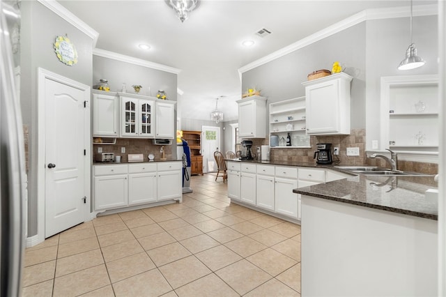 kitchen featuring open shelves, ornamental molding, a sink, light tile patterned floors, and decorative backsplash