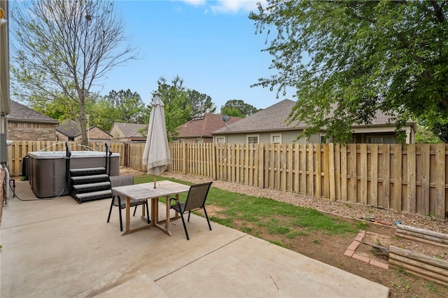 view of patio with a fenced backyard, a hot tub, and outdoor dining space