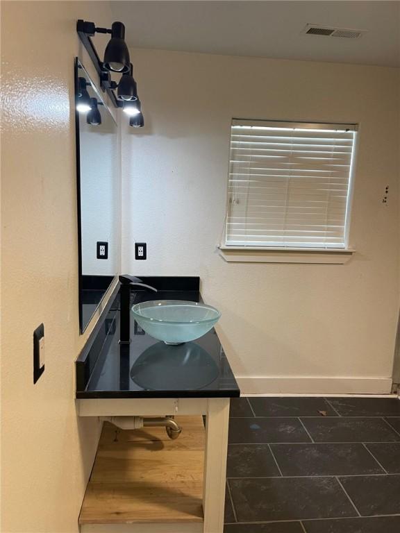 bathroom featuring tile patterned flooring, visible vents, vanity, and baseboards