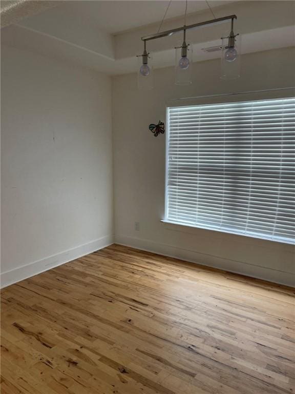 unfurnished room with wood-type flooring and baseboards