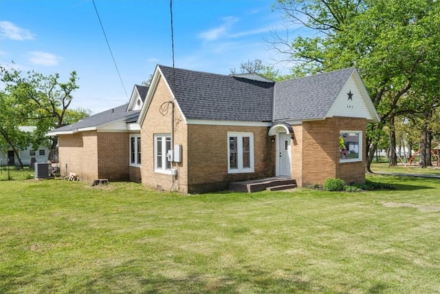 501 SE Main St, Gravette, AR 72736 - view of front facade featuring a shingled roof, brick siding, a front yard, and central AC unit