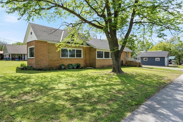 501 SE Main St, Gravette, AR 72736 - view of front of house featuring brick siding, roof with shingles, and a front yard