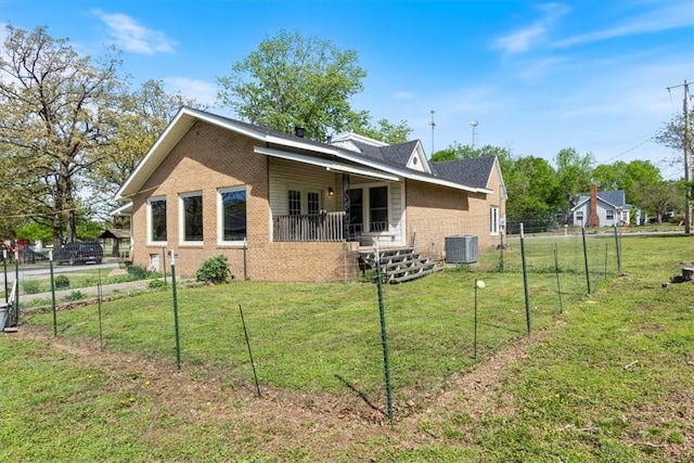 501 SE Main St, Gravette, AR 72736 - view of side of property with brick siding, a yard, central AC unit, and fence