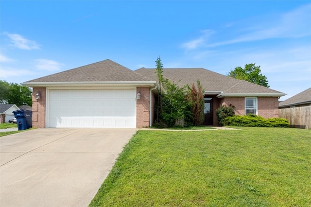 single story home with concrete driveway, a front lawn, an attached garage, fence, and brick siding
