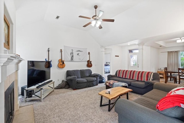 living room with ornate columns, vaulted ceiling, a ceiling fan, light carpet, and a fireplace