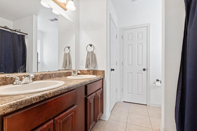 bathroom with tile patterned floors, a sink, visible vents, and double vanity