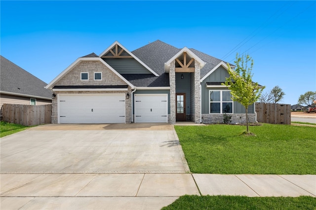 craftsman-style house with concrete driveway, stone siding, a front yard, an attached garage, and fence
