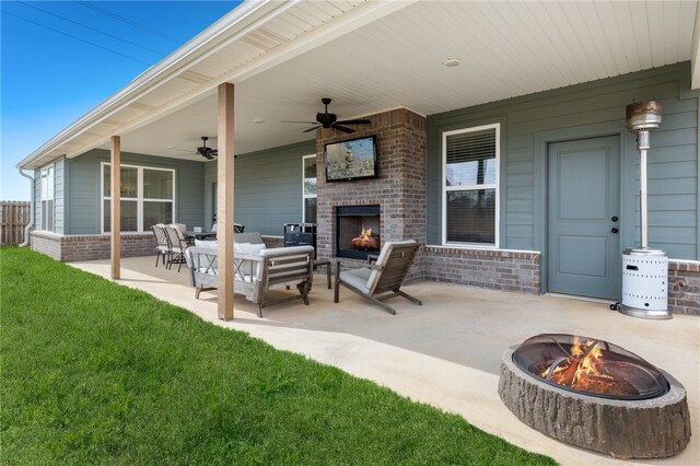 view of patio / terrace featuring an outdoor brick fireplace, a ceiling fan, and an outdoor fire pit