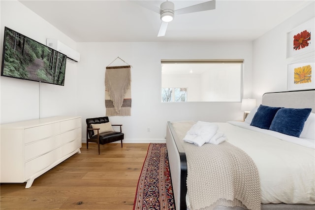 502 SE Tourmaline Mews, Bentonville, AR 72712 - bedroom featuring light wood-type flooring, a wall mounted AC, baseboards, and ceiling fan