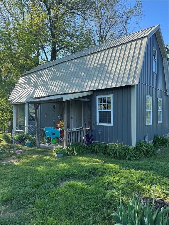 exterior space with a lawn, metal roof, and a gambrel roof