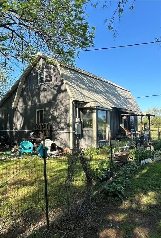 view of home's exterior with a lawn and a gambrel roof