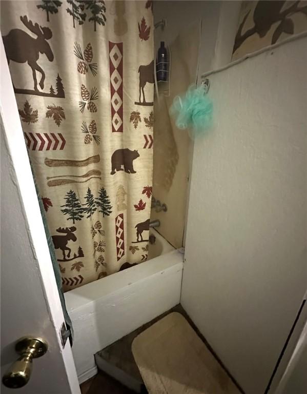bathroom with shower / bath combo with shower curtain