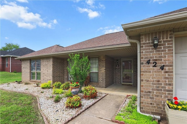 424 W Tanner Dr, Fayetteville, AR 72701 - doorway to property with a shingled roof and brick siding
