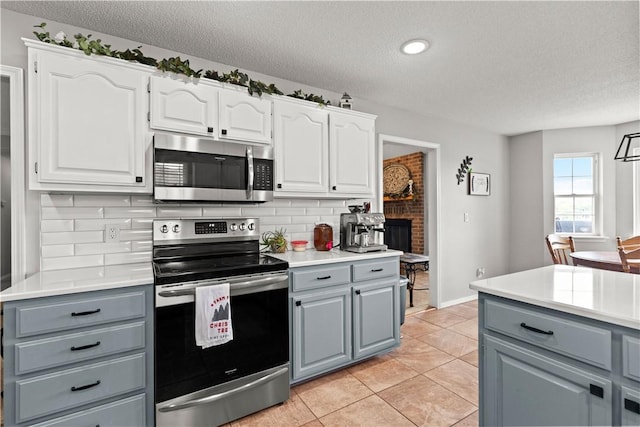 424 W Tanner Dr, Fayetteville, AR 72701 - kitchen featuring gray cabinets, stainless steel appliances, and a textured ceiling