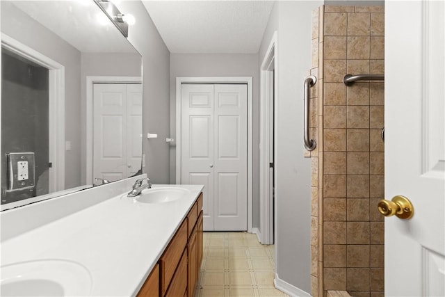 424 W Tanner Dr, Fayetteville, AR 72701 - bathroom with tile patterned floors, a tile shower, double vanity, and a sink