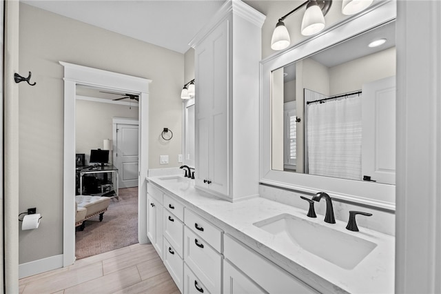 full bath with wood finished floors, a ceiling fan, double vanity, and a sink