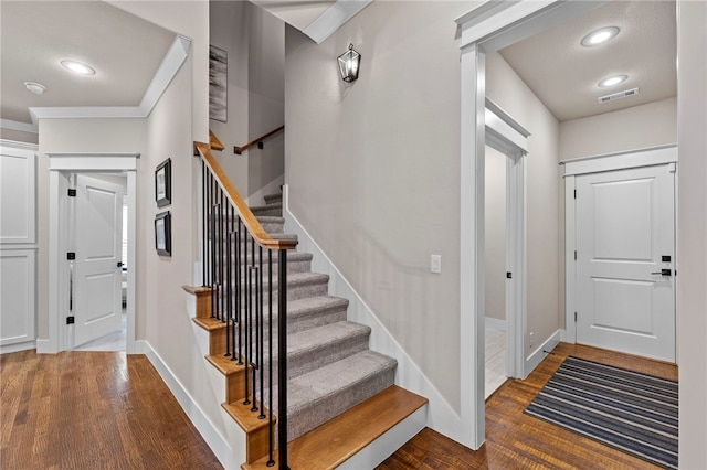 entrance foyer featuring dark wood-style floors, visible vents, stairway, and baseboards