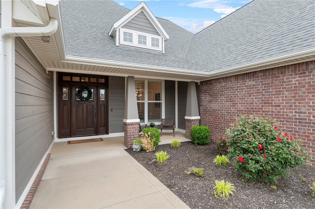 8705 Flycatcher Pl, Bentonville, AR 72713 - entrance to property with brick siding, a shingled roof, and a porch