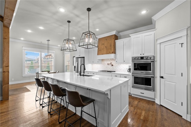 kitchen featuring a kitchen breakfast bar, tasteful backsplash, a sink, appliances with stainless steel finishes, and recessed lighting