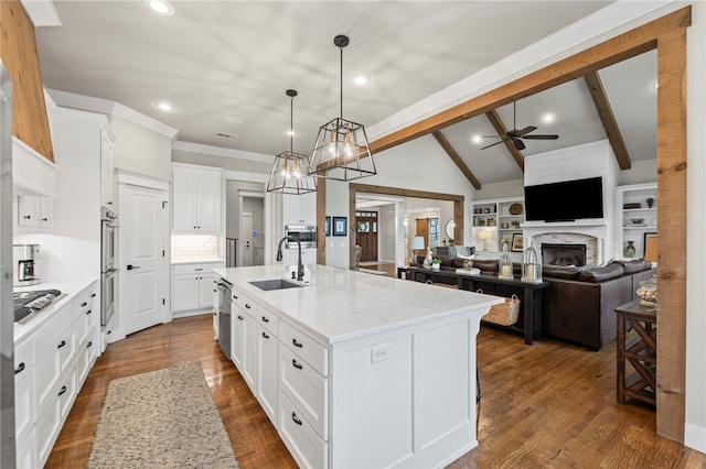 kitchen featuring a center island with sink, a ceiling fan, white cabinets, and a sink