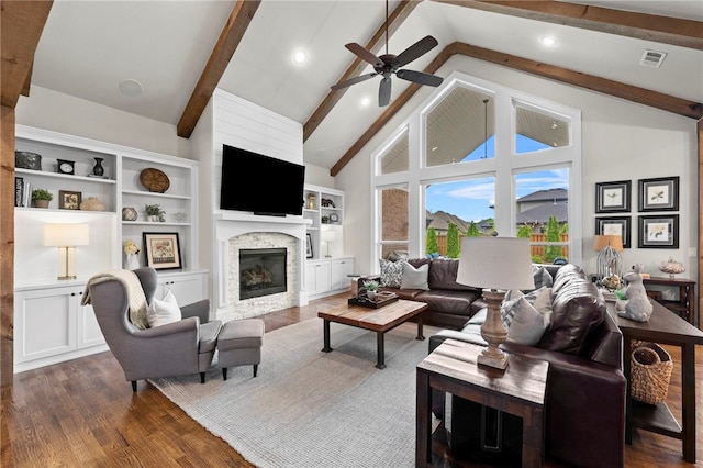 living area with visible vents, ceiling fan, dark wood-style floors, beam ceiling, and a fireplace