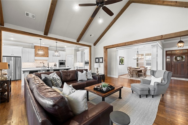 living room featuring beam ceiling, high vaulted ceiling, dark wood-type flooring, visible vents, and ceiling fan with notable chandelier