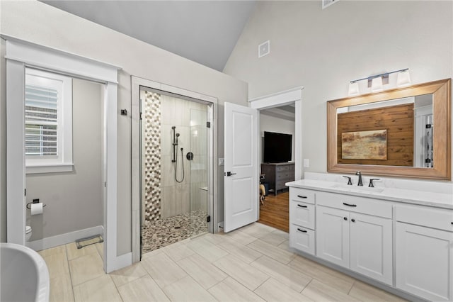 full bathroom with a shower stall, vanity, toilet, visible vents, and baseboards