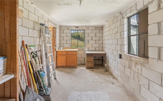 bathroom with concrete flooring and concrete block wall
