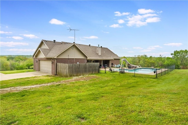 exterior space featuring a lawn, driveway, brick siding, an attached garage, and fence