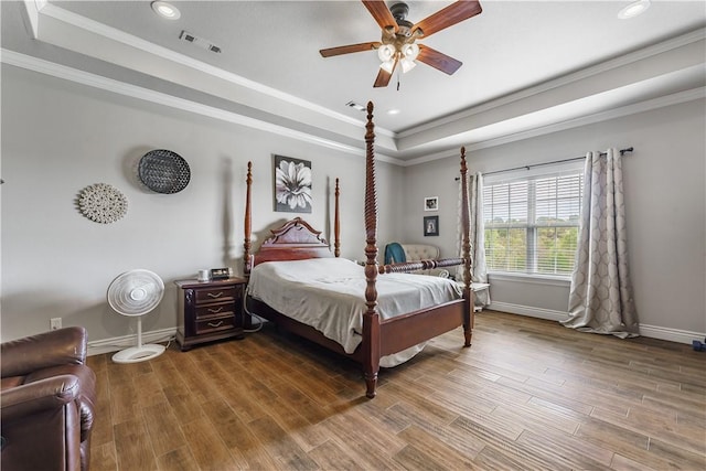 bedroom featuring recessed lighting, wood finished floors, baseboards, visible vents, and a raised ceiling