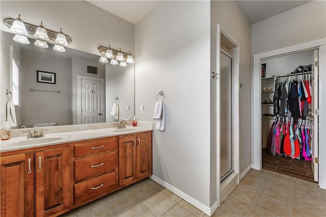 bathroom featuring tile patterned flooring, a sink, a shower stall, and double vanity