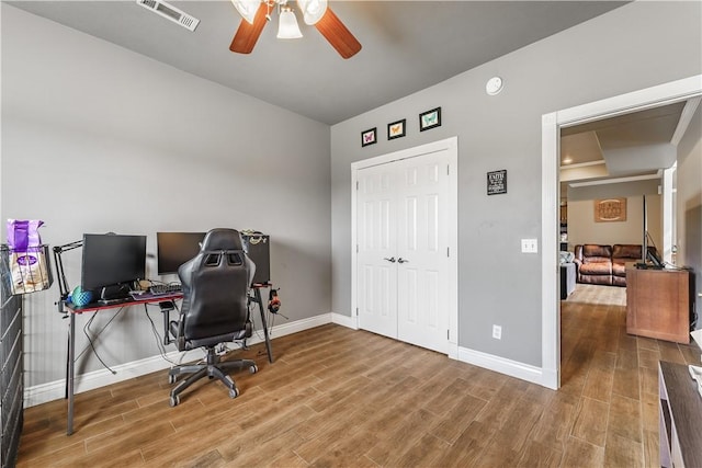 office space featuring visible vents, a ceiling fan, and baseboards