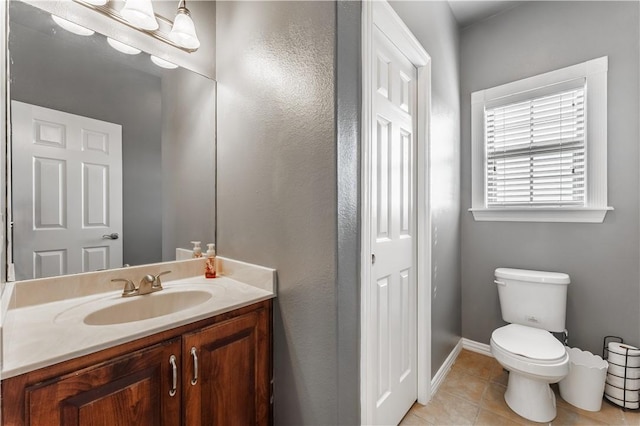 bathroom with vanity, toilet, tile patterned flooring, and baseboards