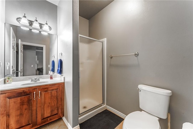 bathroom with baseboards, a stall shower, toilet, and vanity