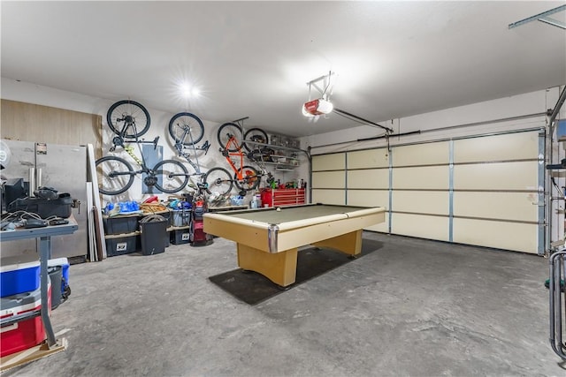 playroom with a garage, unfinished concrete flooring, and pool table