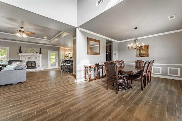dining room featuring ornamental molding, dark wood-style floors, visible vents, and ceiling fan with notable chandelier