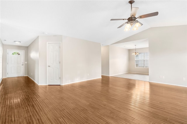 1600 N Stable Ave, Fayetteville, AR 72703 - unfurnished living room featuring baseboards, wood finished floors, ceiling fan with notable chandelier, and vaulted ceiling