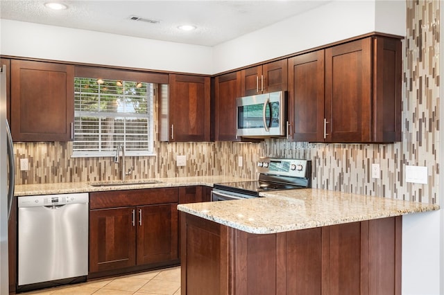 1600 N Stable Ave, Fayetteville, AR 72703 - kitchen featuring light stone counters, appliances with stainless steel finishes, a sink, visible vents, and a peninsula